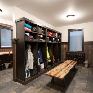 Custom boot room design with ski storage & snow board storage & tuning workstation designed by Big White custom chalet builder & Kelowna custom home builder designer