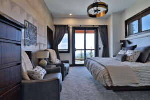 Warm bedroom design with panoramic views of the Monashee Mountains from master bedroom designed & built by Weninger Construction
